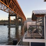 boat house with metal roof under bridge
