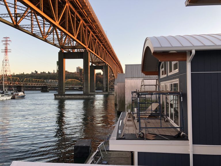 boat house with metal roof under bridge