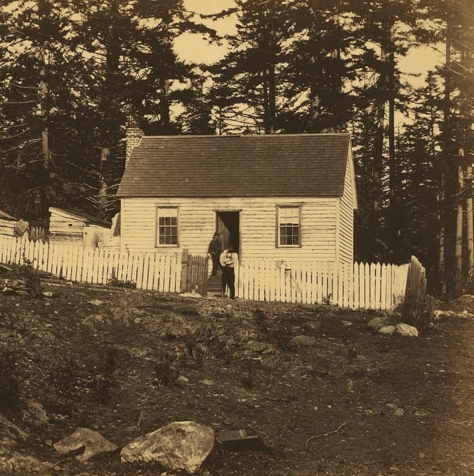 Home in Esquimalt, BC, 1859 with a shingled roof and white picket fence in front