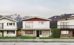 A row of 3 Vancouver Special homes with the North Shore mountains in the background