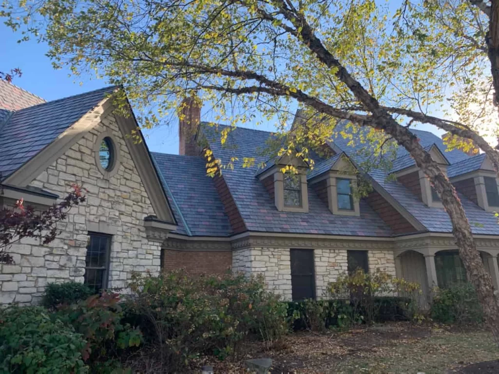 Stone home with Enviroslate roofing, tree in foreground